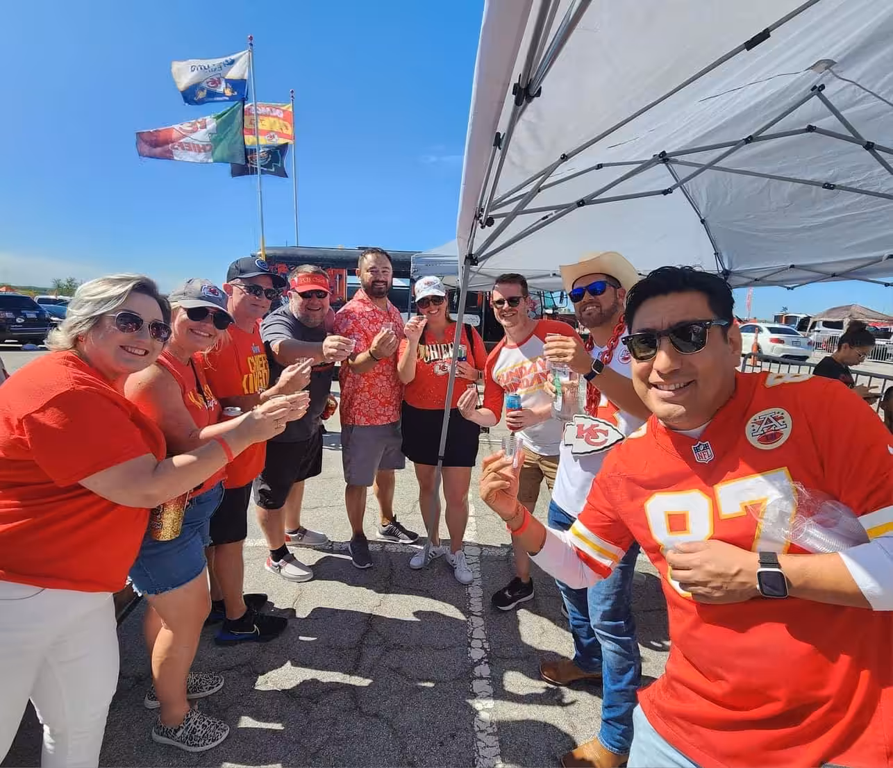 Group of Chiefs fans cheering at a Red Machine tailgate Group of Chiefs fans cheering at a Red Machine tailgate